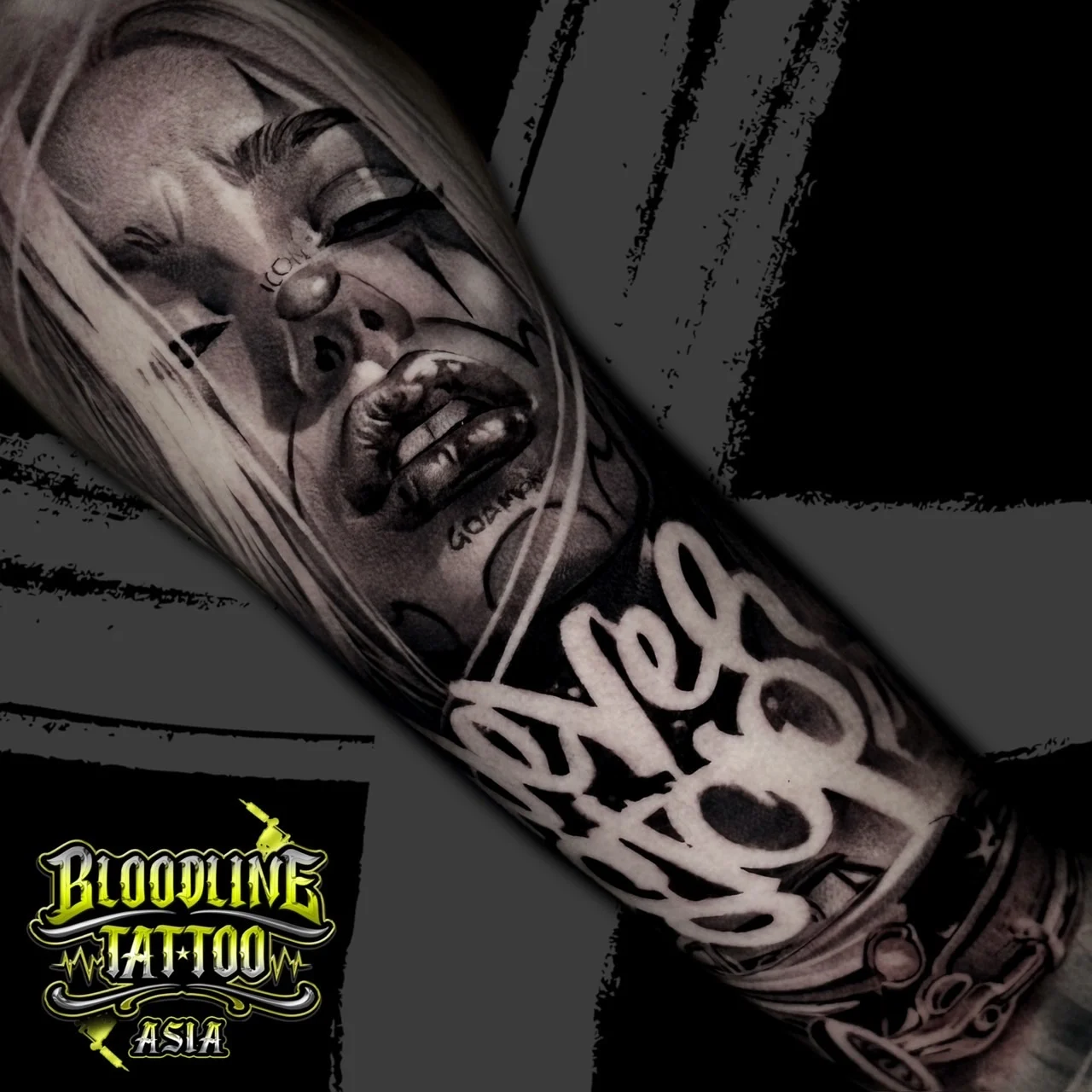 Black and grey Chicano arm tattoo featuring a payasa clown-girl portrait, Never Stop script, and classic lowrider chrome grille at Bloodline Tattoo Bangkok.