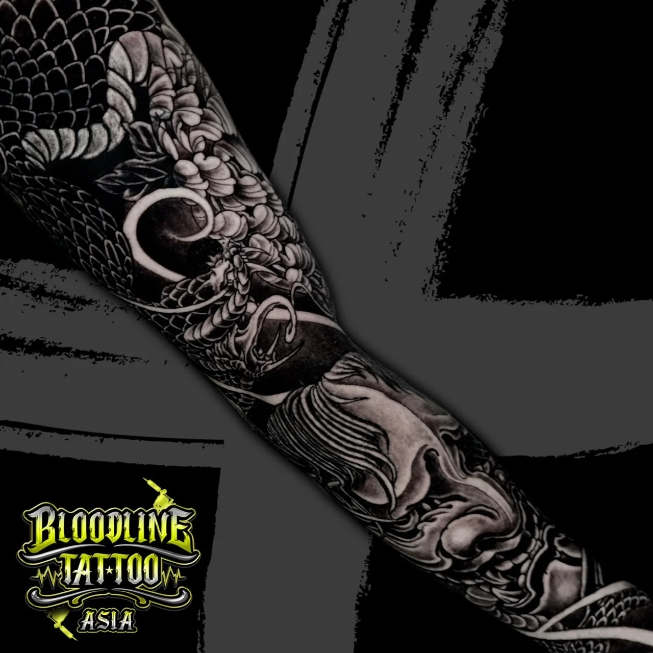 Black and grey Japanese Irezumi sleeve with coiled dragon, Hannya mask, peonies, and dark mikiri background at Bloodline Tattoo Bangkok.