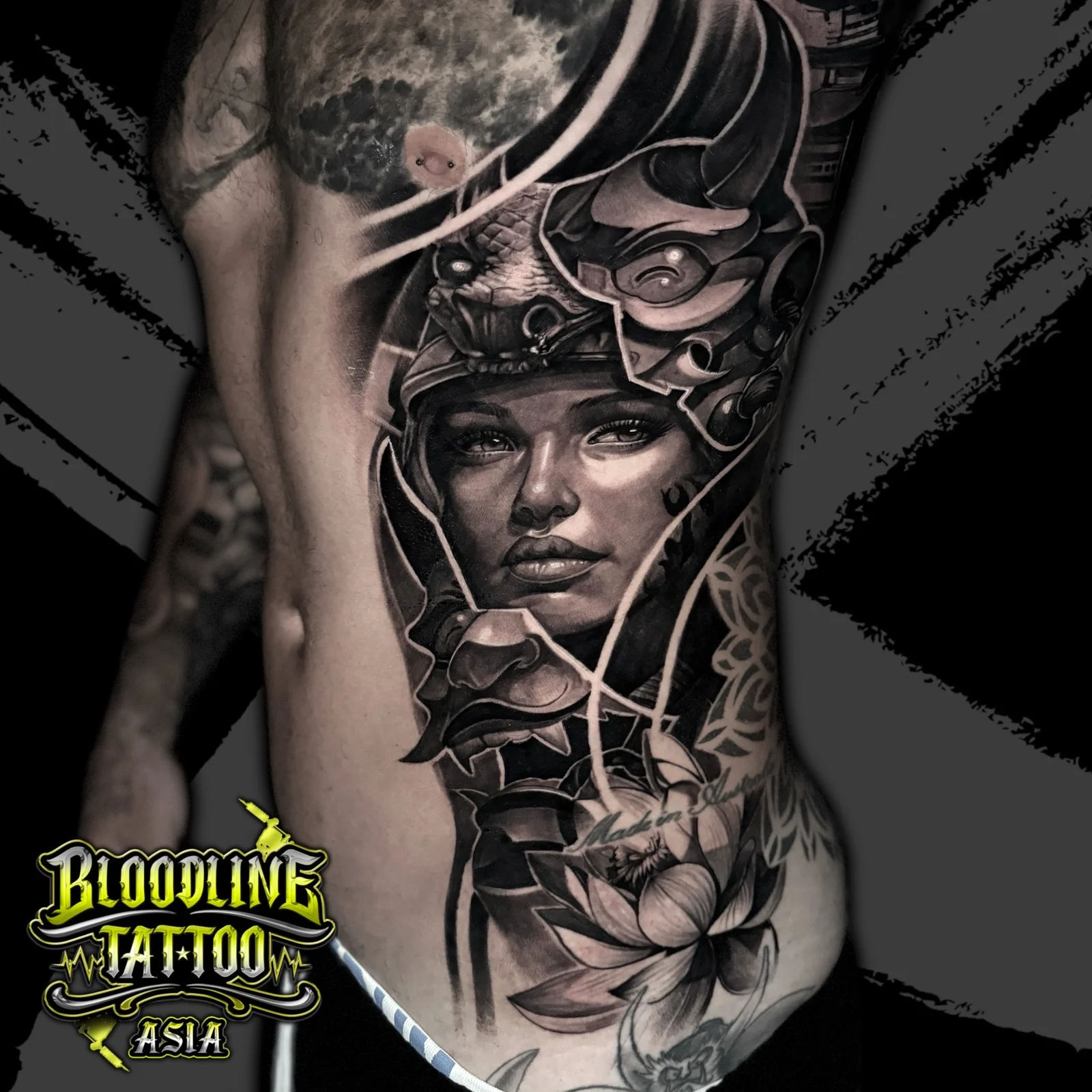 Black and grey Japanese side tattoo of a woman portrait with Hannya and dragon headpiece, lotus, and mandala at Bloodline Tattoo Bangkok.