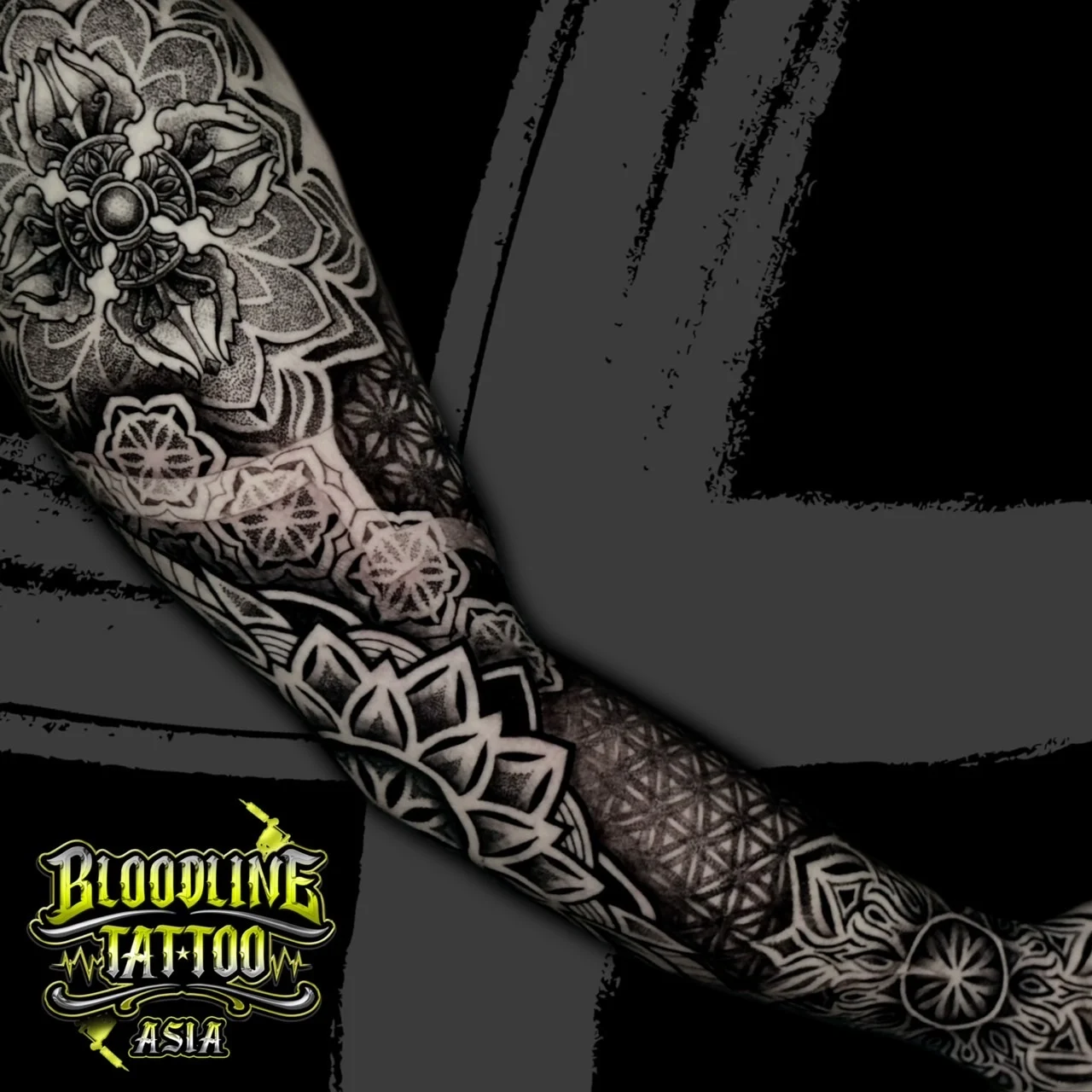 Diagonal full-arm sleeve with shoulder mandala, mid-arm hex florals, forearm Flower of Life grid, and wrist mandala accents in dotwork, at Bloodline Tattoo Bangkok.