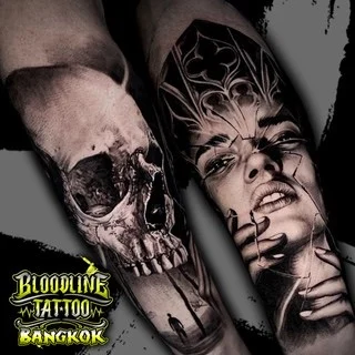 A black and grey realism forearm sleeve pairing a detailed human skull with a woman's face seen through shattered glass and gothic architecture, at Bloodline Tattoo Bangkok.
