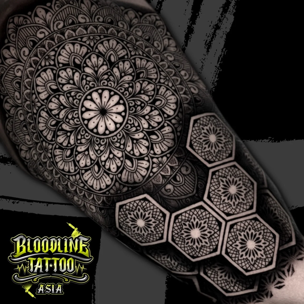A black and grey realism sleeve of an intricate mandala above a honeycomb of hexagonal geometric patterns with fine dotwork, at Bloodline Tattoo Bangkok.